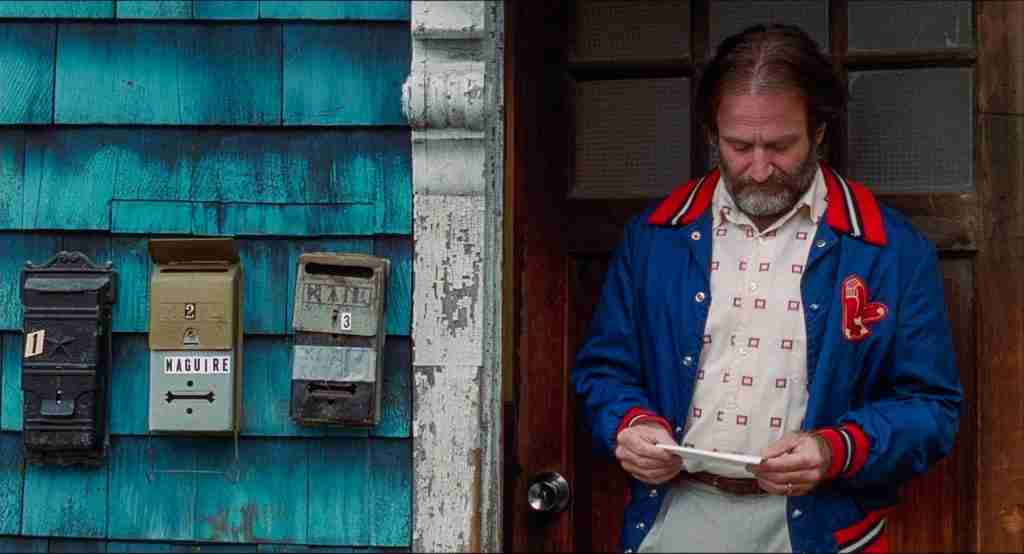 Robin Williams as Sean Maguire looking down at Will's letter before reading it in Good Will Hunting analysis.