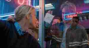 Matt Damon as Will Hunting holding up Skylar's phone number note in the iconic "How do you like them apples" bar scene from Good Will Hunting analysis.