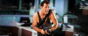 John McClane in bloodied tank top gripping MP5 machine gun running from Hans Gruber’s goons in Nakatomi Plaza after Hans reveals himself in Die Hard (1988) – key escape moment from the Die Hard beat sheet