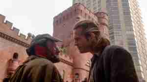 Robin Williams as Parry and Jeff Bridges as Jack in The Fisher King (1991), facing each other outside a castle-like building as Parry tries to enlist Jack’s help for the Grail quest – pivotal scene from the Fisher King beat sheet.