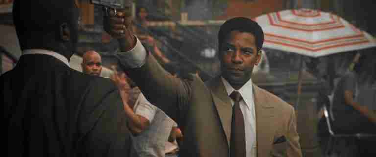 Frank Lucas holding a gun to Tango's head on a crowded street in Harlem.