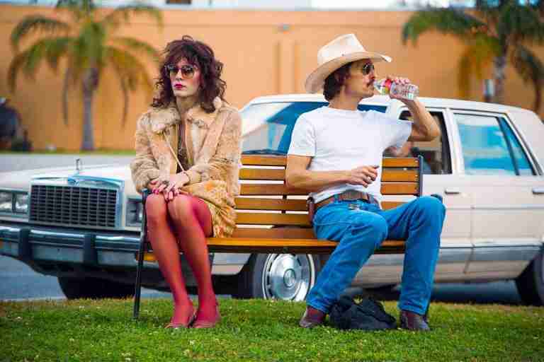 Ron Woodroof and Rayon sitting on a bench, representing the Dallas Buyers Club partnership.