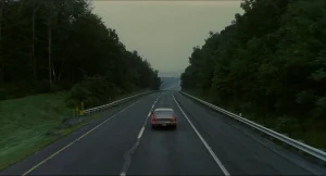 Will's car driving alone down a tree-lined highway in the final shot of Good Will Hunting.