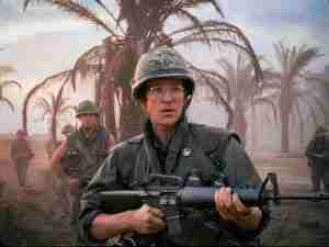 Full Metal Jacket Joker on patrol with "Born to Kill" helmet and peace button, symbolizing the duality of man and the film's central paradox of war