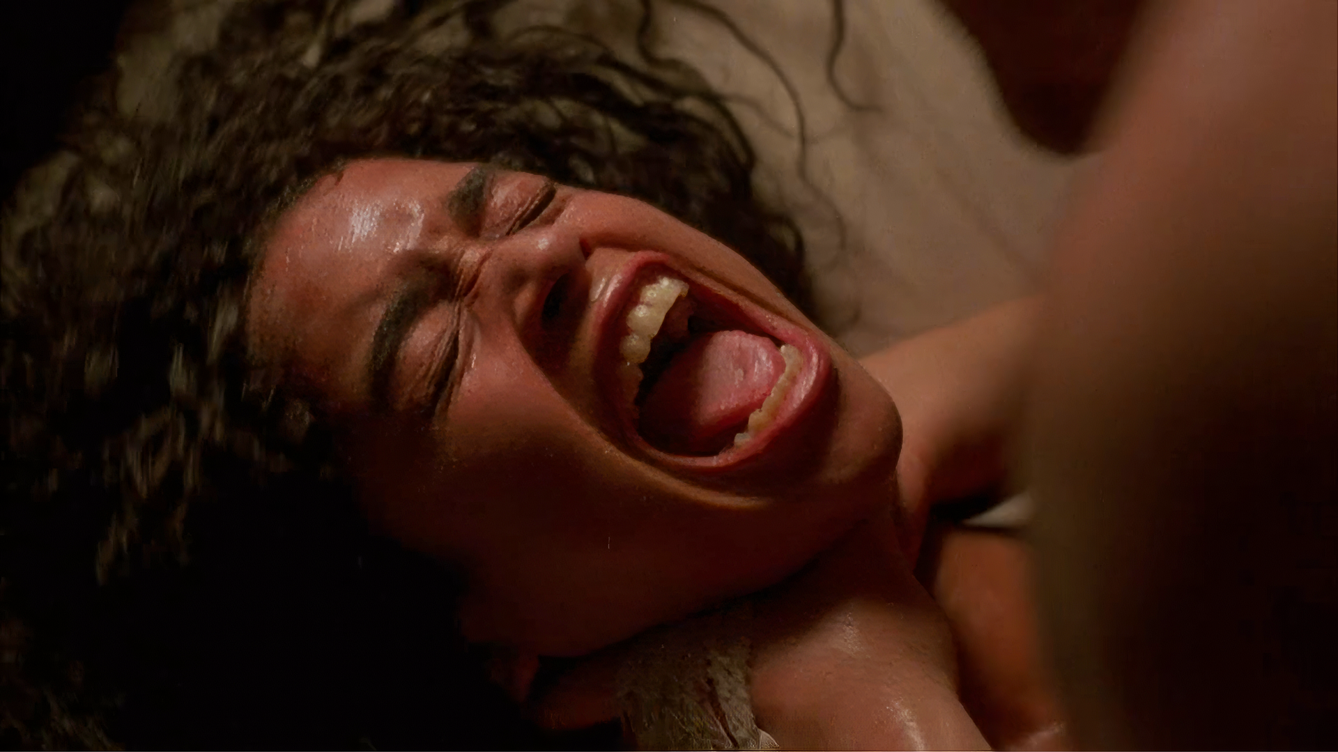 Angel Heart MPAA controversy — close-up of Harry Angel strangling Epiphany Proudfoot during the blood-rain sex scene, the sequence that earned Alan Parker's 1987 film an X rating