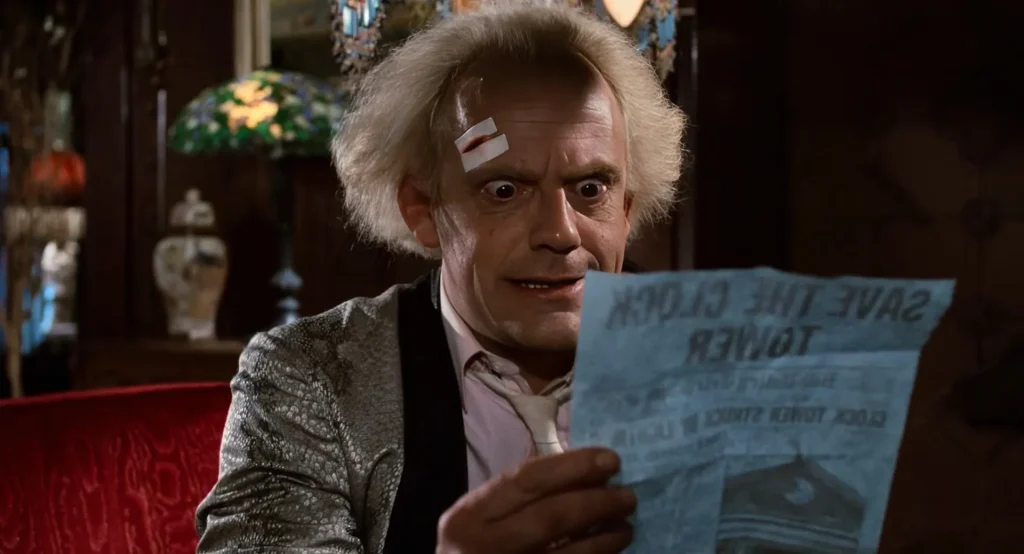 Doc Brown holding up the Save the Clock Tower flyer in his 1955 mansion, Back to the Future foreshadowing payoff