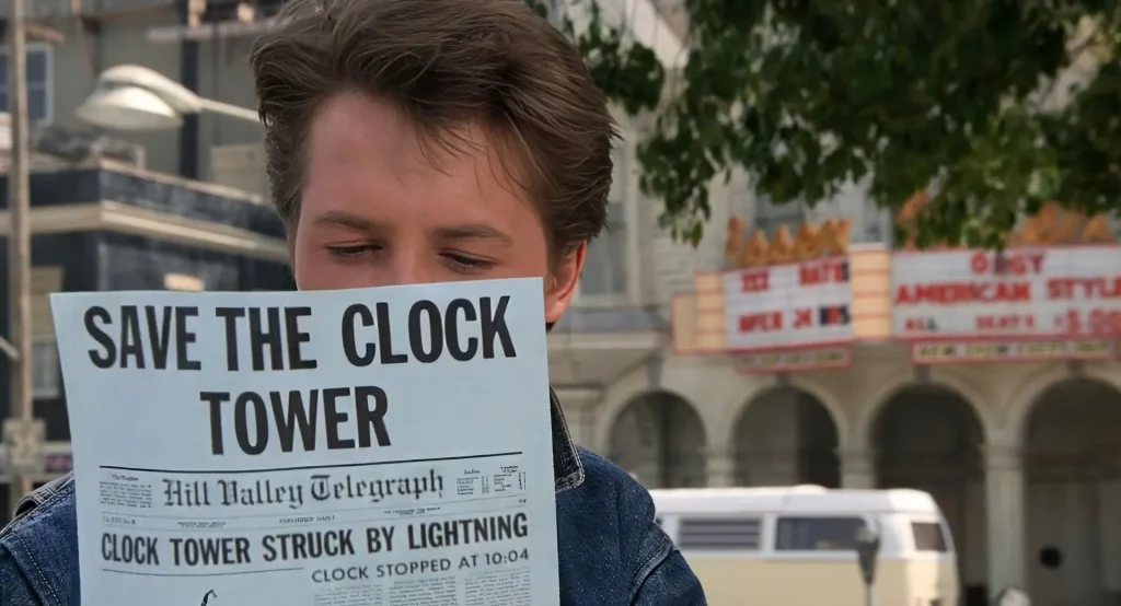 Marty McFly holding a Save the Clock Tower flyer showing a lightning strike headline, setups and payoffs in Back to the Future