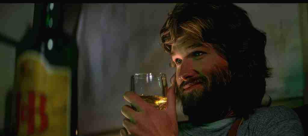MacReady smirks with J&B Scotch during chess in The Thing 1982 analysis – ego before loss and paranoia metaphor