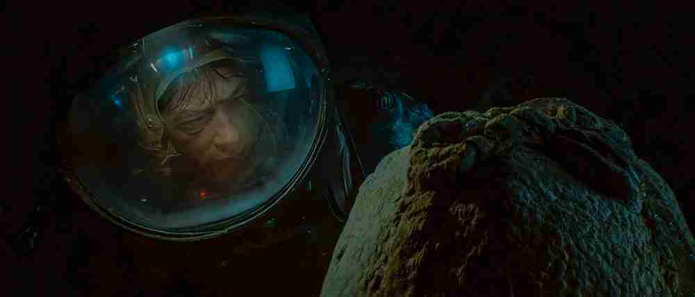 Kane inspects the Alien egg just before the facehugger attack, illustrating the fatal end of the Debate beat.