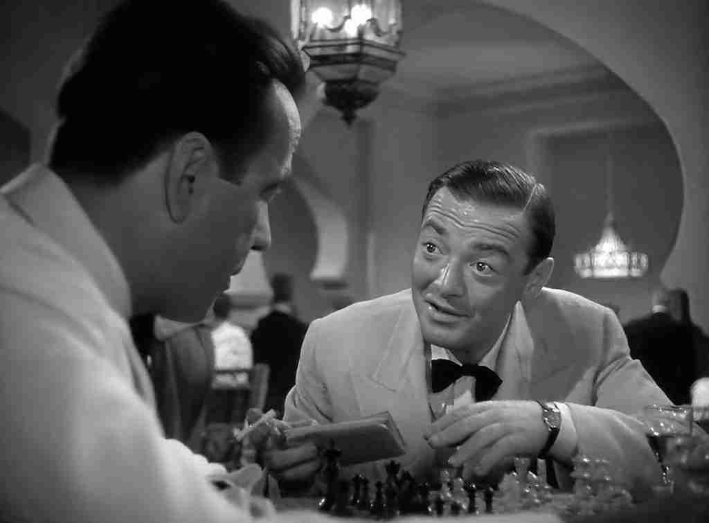Rick Blaine and Ugarte discussing the letters of transit over a chess game, representing the Inciting Incident.