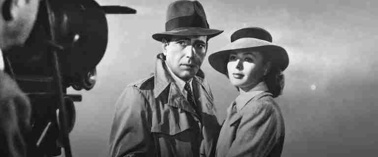 Humphrey Bogart and Ingrid Bergman in a wide shot at the airport, featured image for the Casablanca beat sheet.