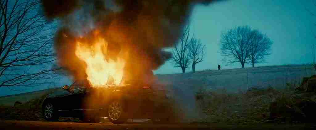 Michael Clayton's car explodes, representing the death of the old self and the moment of Irreversible Commitment.