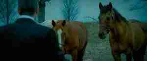 Michael Clayton stands with the horses, representing the thematic turning point and R&C prophecy that saves his life. The image explains the symbolism of the Michael Clayton horses.