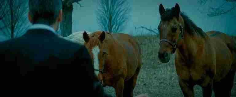 Michael Clayton stands with the horses, representing the thematic turning point and R&C prophecy that saves his life. The image explains the symbolism of the Michael Clayton horses.