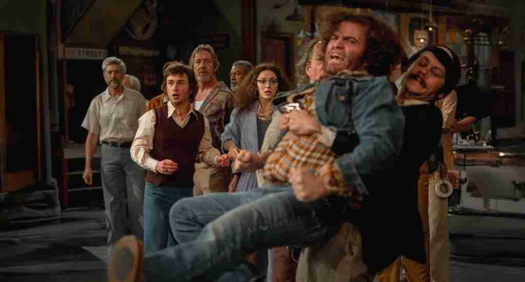 John Belushi is restrained by Dan Aykroyd after the lighting rig crash, highlighting the volatile internal rebellion in the Saturday Night 2024 Beat Sheet.