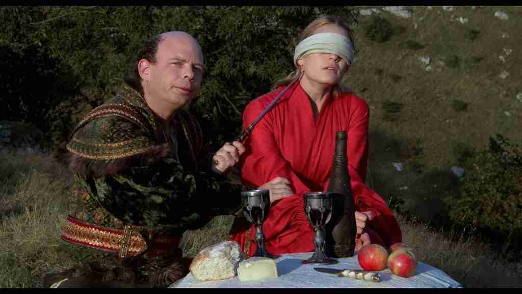 Vizzini holding dagger to blindfolded Buttercup during Battle of Wits with goblets of wine, The Princess Bride
