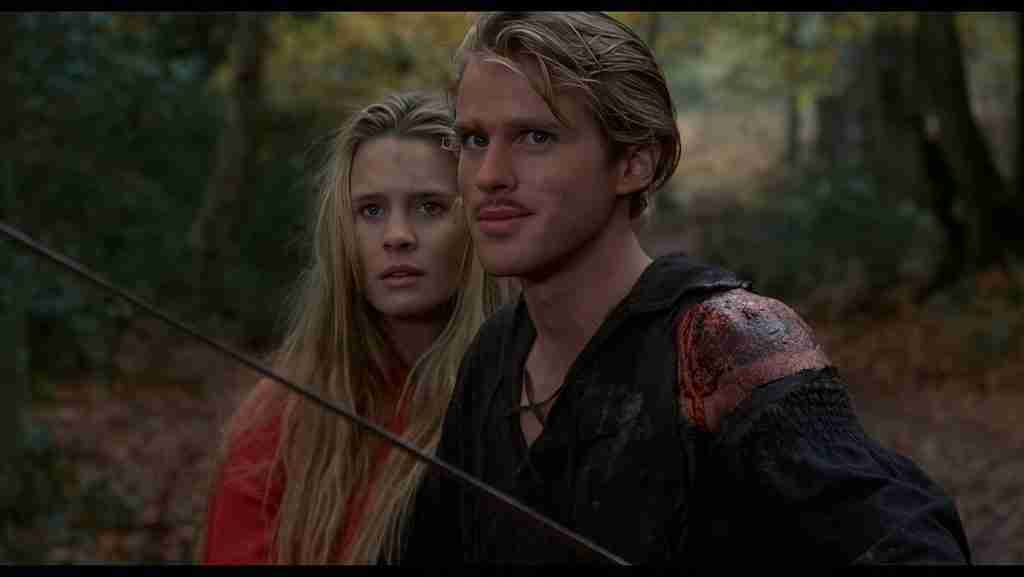 Westley shielding Buttercup with drawn sword, wounded shoulder visible, in The Princess Bride Fire Swamp exit scene