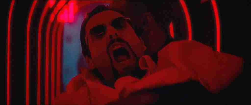 Howard Ratner (Adam Sandler) shouting while being forcibly removed from a nightclub bathed in red light for an Uncut Gems analysis of character conflict.