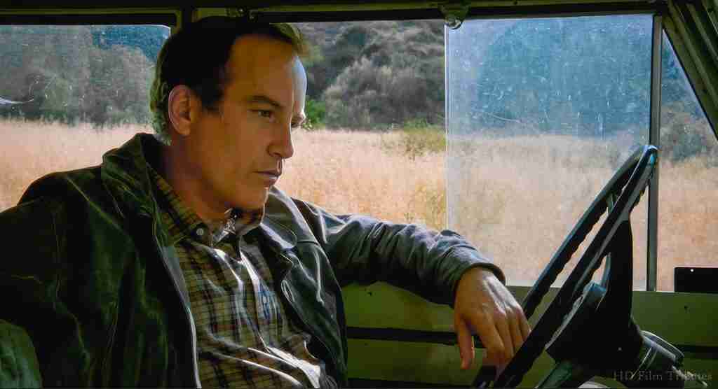 Stand By Me analysis: Richard Dreyfuss as adult Gordie Lachance parked, gazing thoughtfully out the window in a moment of quiet nostalgia.