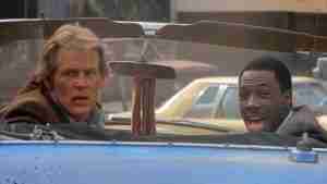 Eddie Murphy as Reggie Hammond laughing triumphantly in the convertible as they spot Luther – 48 Hrs movie analysis