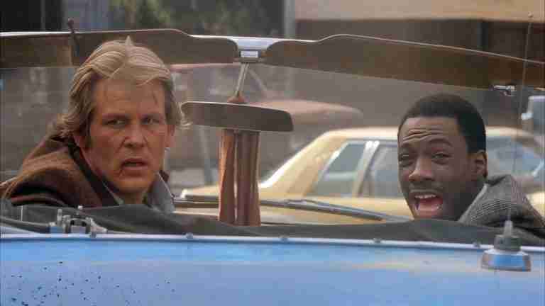 Eddie Murphy as Reggie Hammond laughing triumphantly in the convertible as they spot Luther – 48 Hrs movie analysis