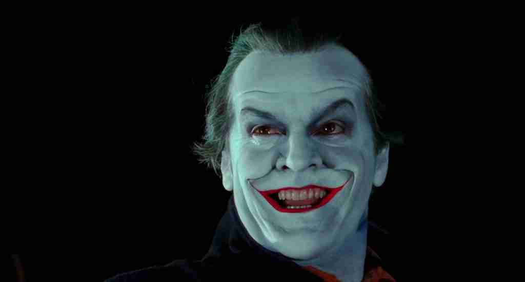 The Joker steps from the shadows to reveal his disfigured face to Carl Grissom before killing him in Batman (1989).