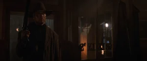 Clint Eastwood as William Munny holding a shotgun inside Greely's saloon at night in Unforgiven (1992)