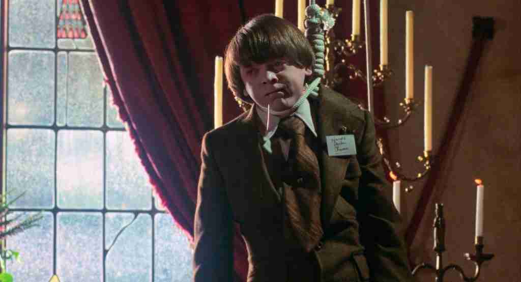 Harold Chasen staging a fake hanging in a mansion as a cry for attention, illustrating the dark comedy tone of the screenplay.