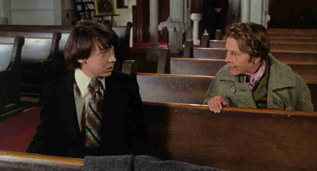 Harold and Maude sitting in church pews during their first meeting at a stranger's funeral.
