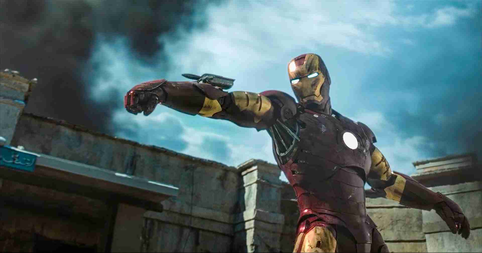 Iron Man in the red and gold Mark III armor aiming a wrist rocket during the Gulmira fight in Afghanistan.