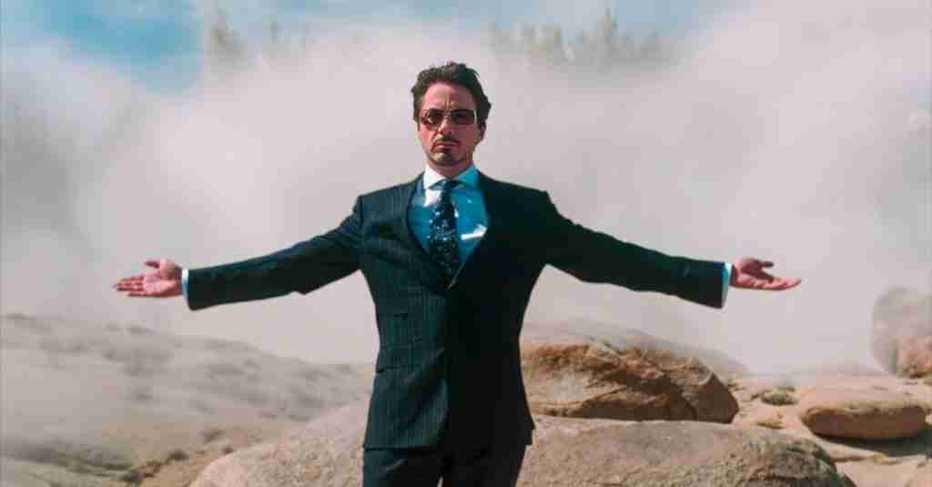 Tony Stark standing in a suit with his arms outstretched as the Jericho missile explodes behind him in the Afghan desert.