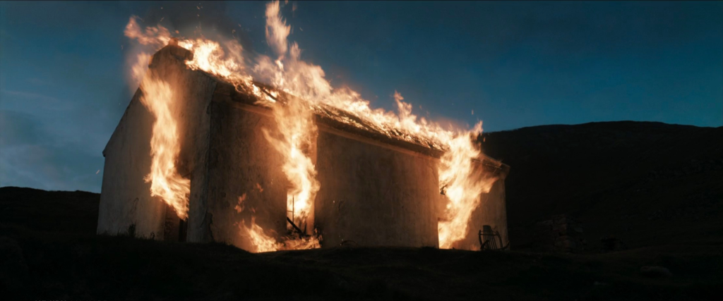 Colm's cottage fully engulfed in flames against the twilight sky in The Banshees of Inisherin ending sequence