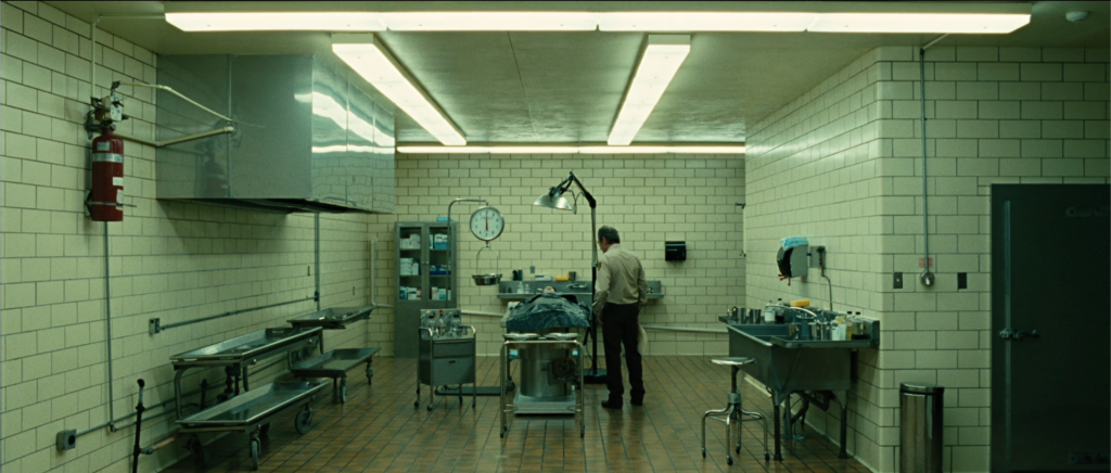 Sheriff Bell standing over Llewelyn Moss's body at the morgue — No Country for Old Men ending explained