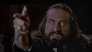 Robert De Niro as Louis Cyphre with glowing yellow eyes pointing at Harry Angel during the Devil reveal in Angel Heart 1987.