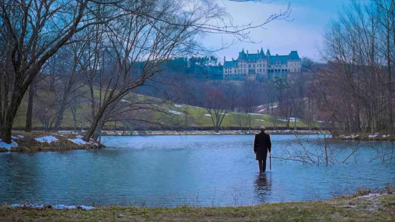 Chance the gardener stands on a pond's surface in the ending of Being There, the estate behind him through bare winter trees.