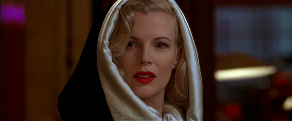 Kim Basinger as Lynn Bracken in L.A. Confidential, wearing a white silk hood over a black coat in the liquor store scene