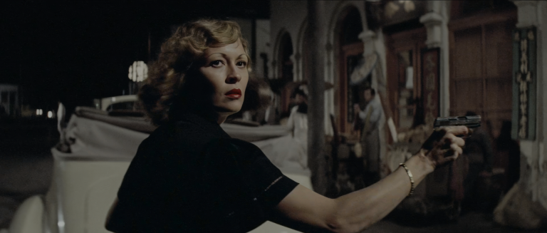aye Dunaway as Evelyn Mulwray at night on a Chinatown street, looking back over her shoulder in a black dress and red lipstick, pointing a pistol off-frame beside a white convertible.