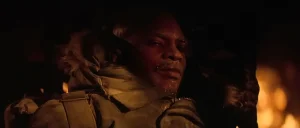 Childs sits frost-covered by the burning outpost in The Thing's final scene, the shot behind the "is Childs the Thing" debate