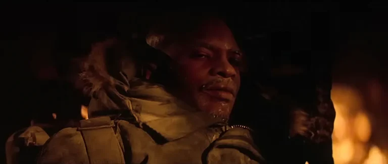 Childs sits frost-covered by the burning outpost in The Thing's final scene, the shot behind the "is Childs the Thing" debate