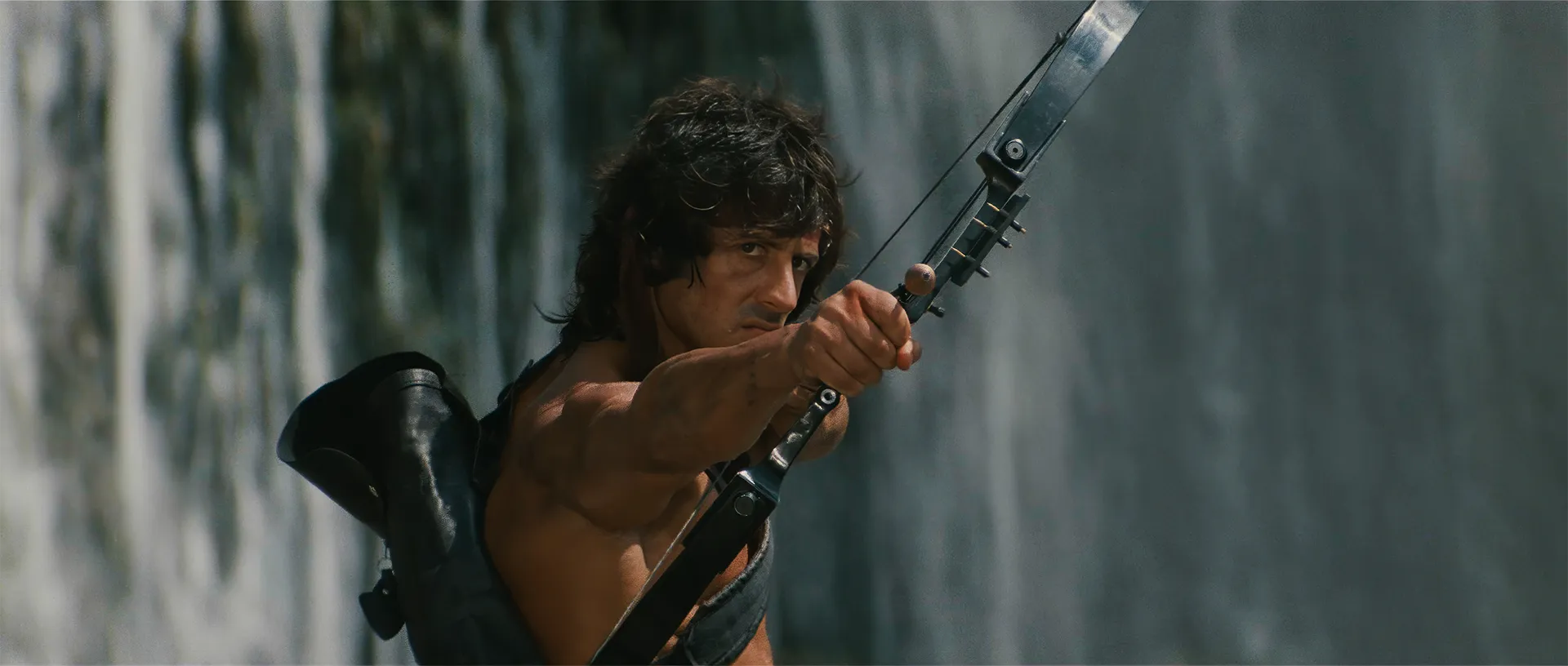 Sylvester Stallone as John Rambo drawing his compound bow in Rambo: First Blood Part II