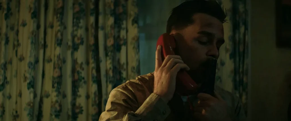 Dixon holds a shotgun against his lips while on the phone in Three Billboards Outside Ebbing, Missouri