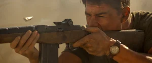 Tom Cruise as Ron Kovic firing a rifle in Born on the Fourth of July
