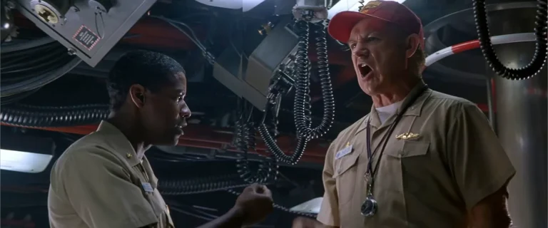 Gene Hackman as Captain Ramsey in a red cap shouts at Denzel Washington as Lieutenant Commander Hunter in the submarine control room in Crimson Tide (1995).