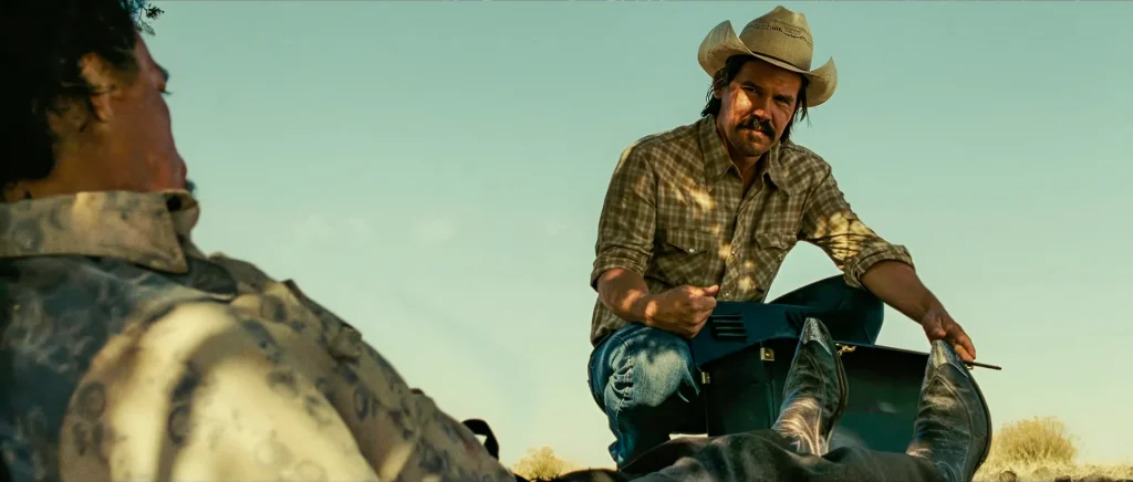 Llewelyn Moss crouched over the open satchel of money at the desert drug-deal scene in No Country for Old Men