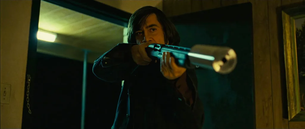 Anton Chigurh (Javier Bardem) aiming the silenced shotgun in a motel doorway; the weapon was custom-built to match McCarthy's description for the No Country for Old Men screenplay